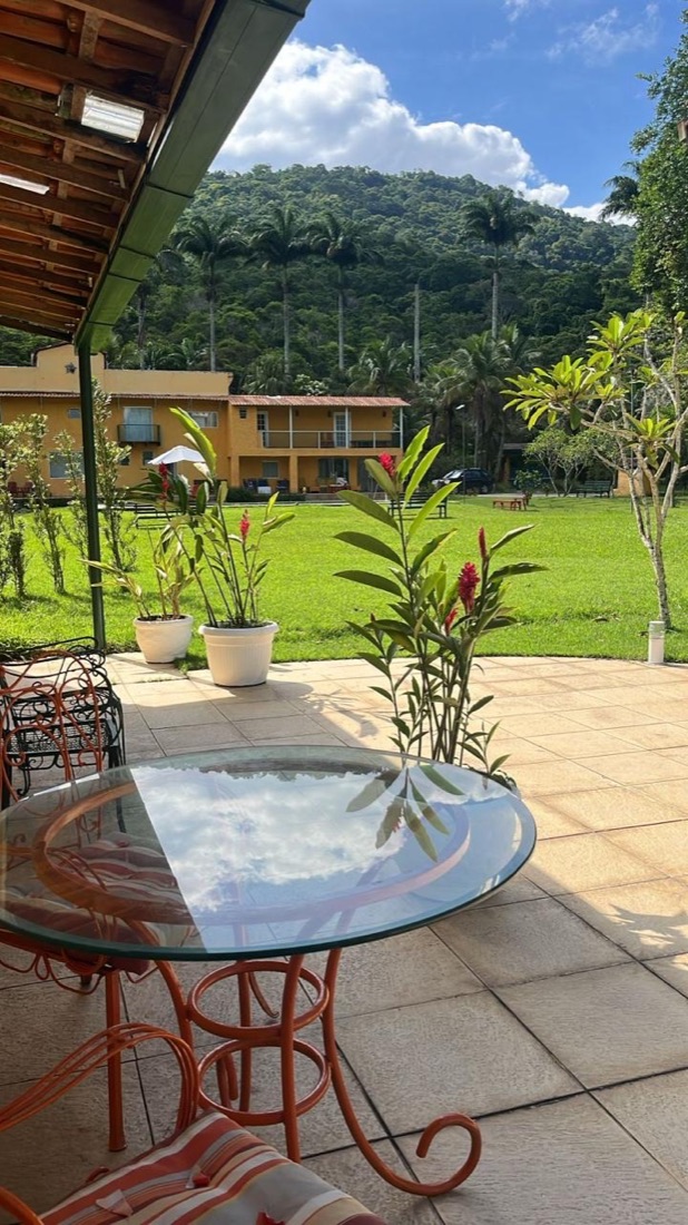 Jardim com plantas em vasos e o edifício de suítes ao fundo